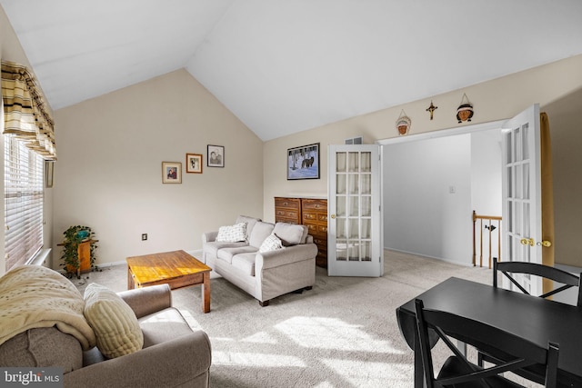 carpeted living room featuring french doors and lofted ceiling