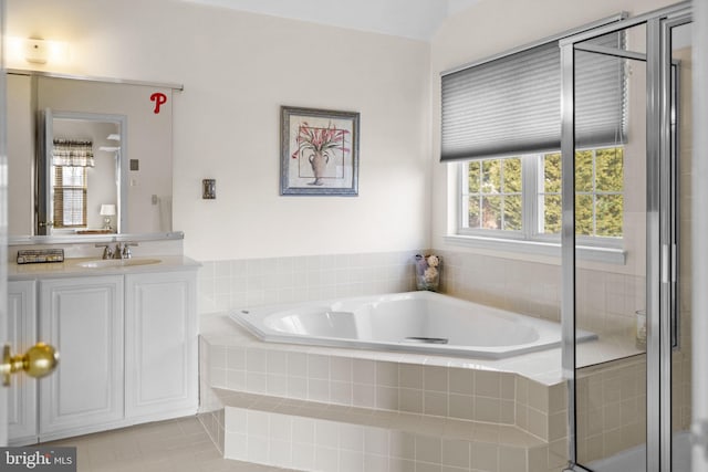 bathroom featuring tile patterned floors, separate shower and tub, vanity, and vaulted ceiling