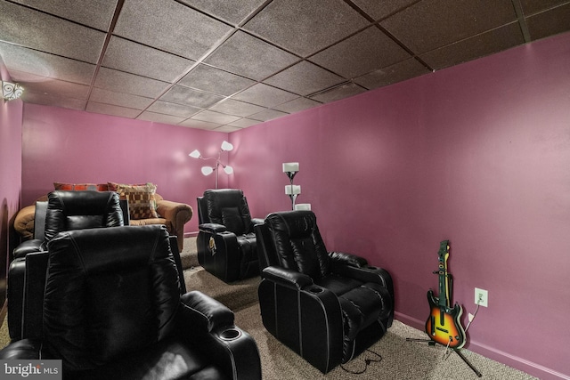 carpeted home theater room with a drop ceiling