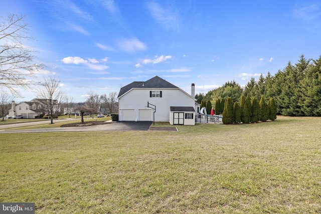 back of house featuring a lawn and a garage