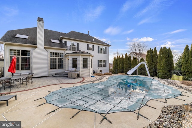 view of pool with a patio and a water slide