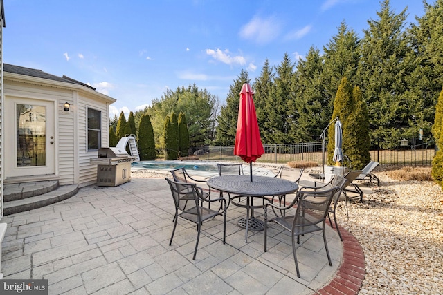 view of patio with area for grilling and a fenced in pool