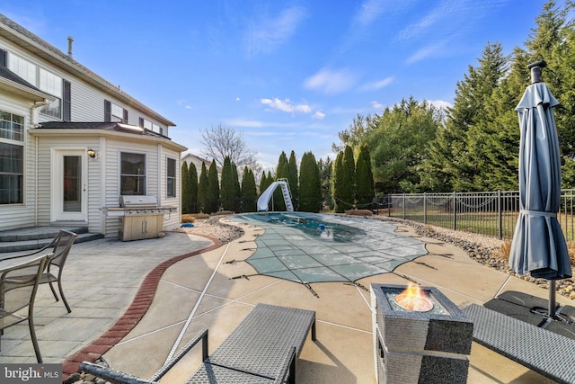 view of pool featuring a fire pit, a patio area, and a water slide