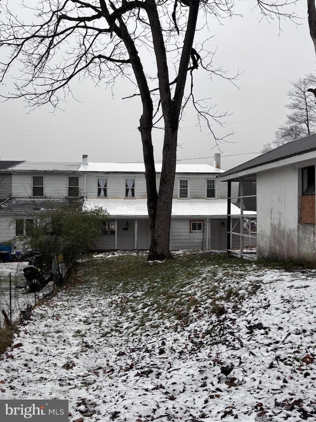 view of snow covered rear of property