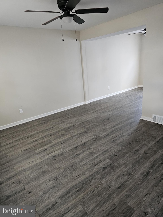 unfurnished room with ceiling fan and dark wood-type flooring