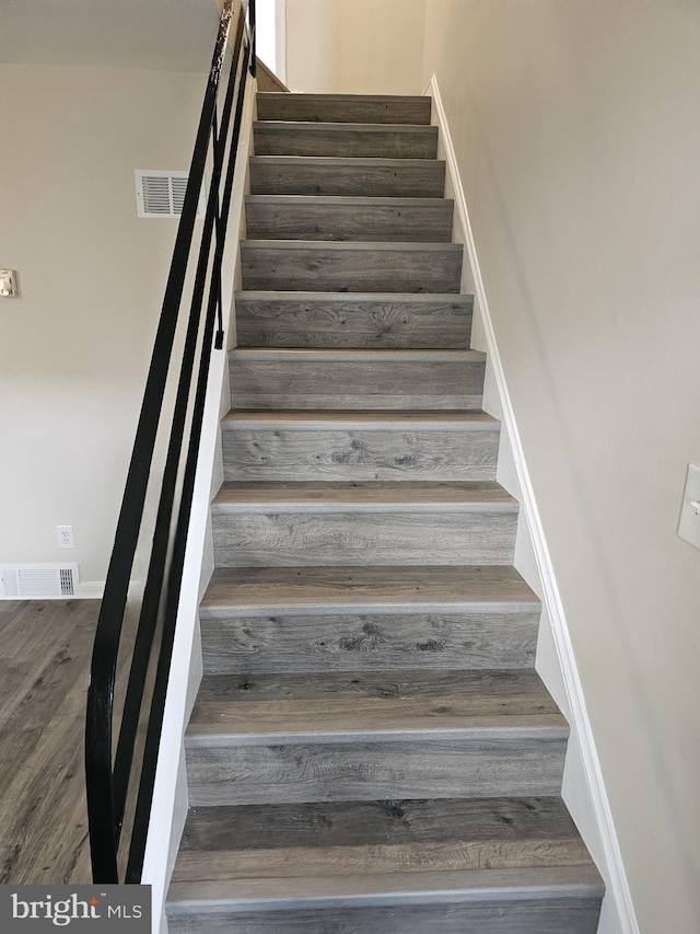 staircase with hardwood / wood-style flooring