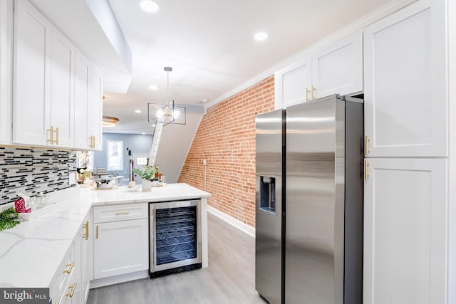 kitchen with brick wall, white cabinets, beverage cooler, and stainless steel refrigerator with ice dispenser