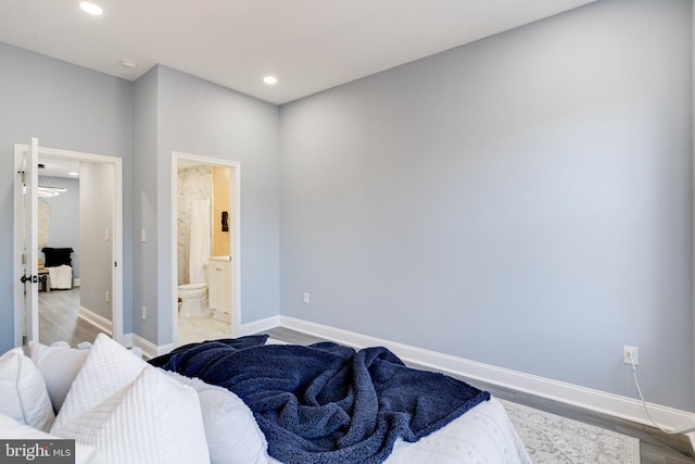 bedroom featuring connected bathroom and light hardwood / wood-style flooring