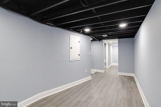 basement with hardwood / wood-style floors and electric panel