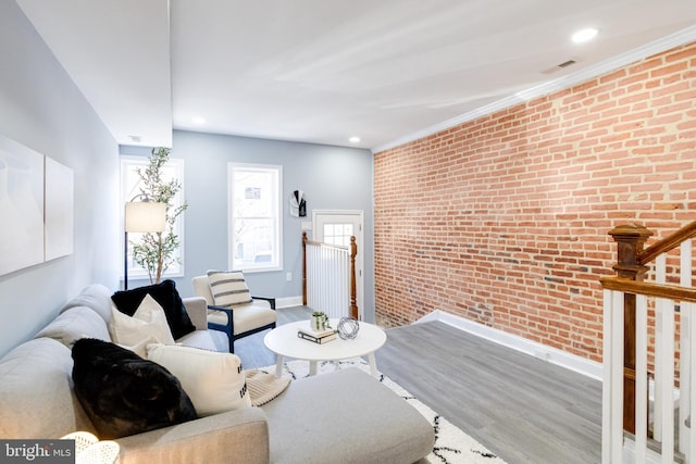 living room with hardwood / wood-style floors and brick wall