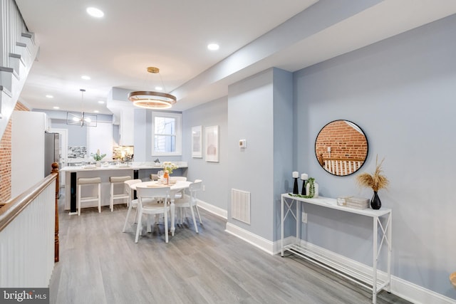 dining room with an inviting chandelier and light hardwood / wood-style flooring