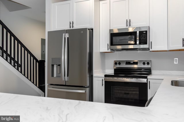 kitchen with white cabinets, light stone countertops, and appliances with stainless steel finishes