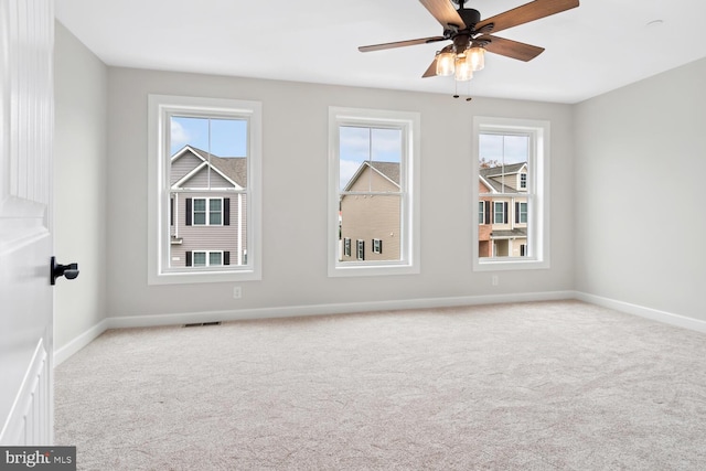 spare room with ceiling fan and light colored carpet