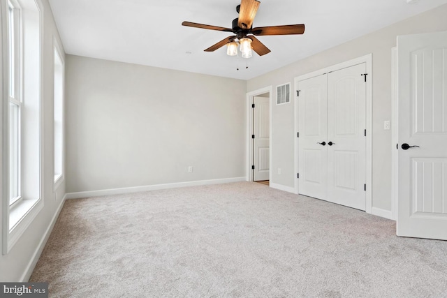 unfurnished bedroom featuring ceiling fan and light colored carpet