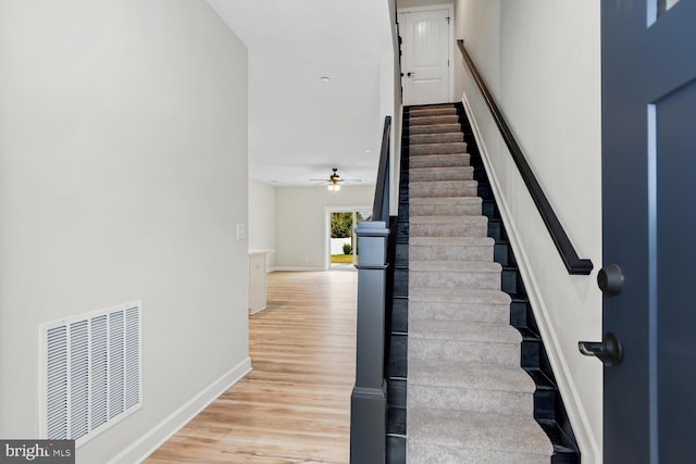 stairs with ceiling fan and hardwood / wood-style floors