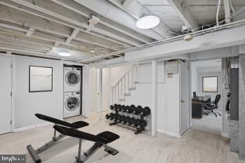 exercise area with stacked washer and clothes dryer