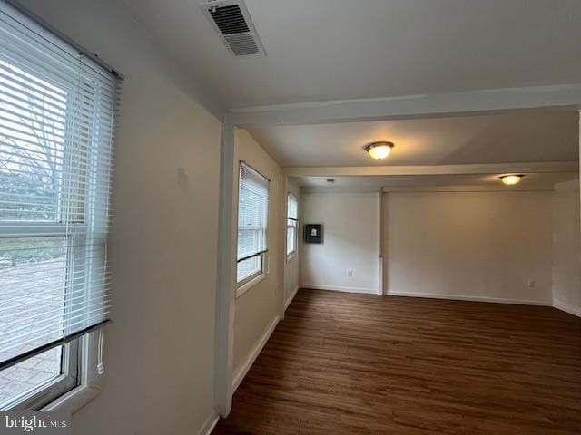 unfurnished room featuring dark hardwood / wood-style flooring and a wealth of natural light