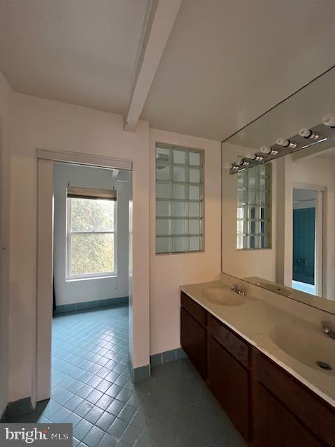 bathroom featuring tile patterned flooring, beam ceiling, and vanity