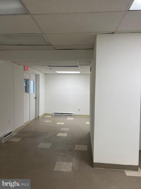 interior space with a baseboard radiator and a drop ceiling