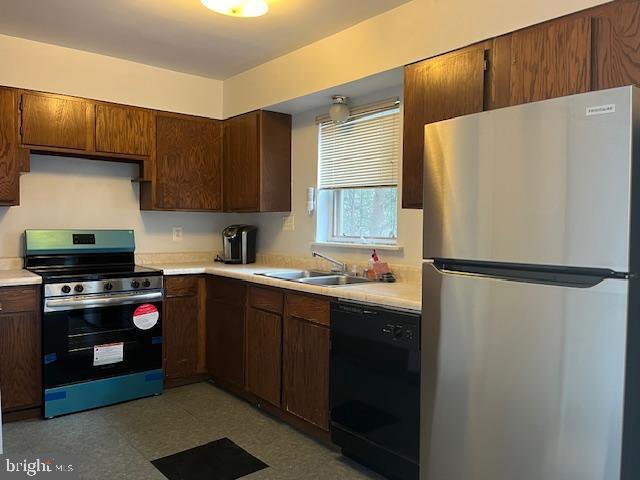 kitchen with stainless steel fridge, stove, sink, and black dishwasher