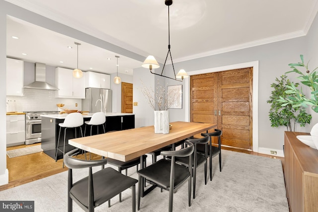 dining area with light hardwood / wood-style flooring and crown molding