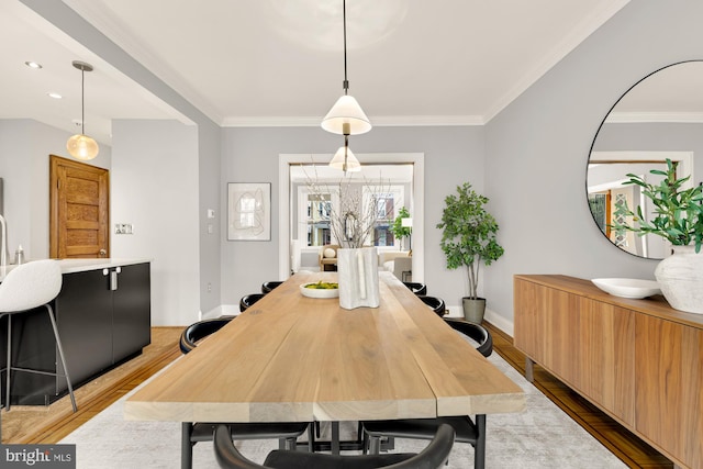 dining room with light hardwood / wood-style floors and ornamental molding