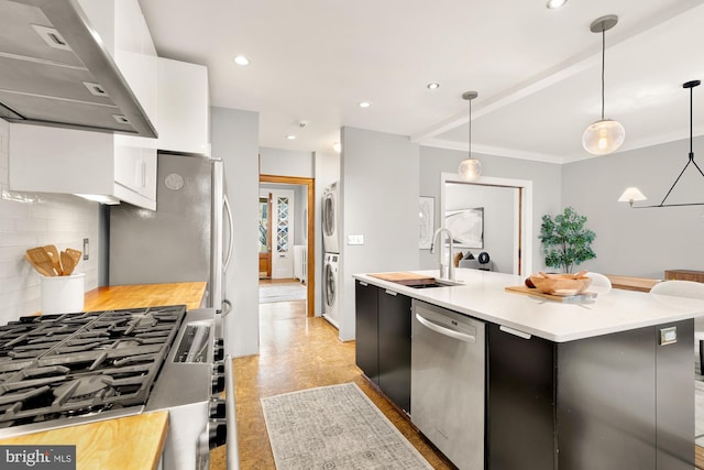 kitchen featuring dishwasher, exhaust hood, decorative light fixtures, tasteful backsplash, and a kitchen island with sink