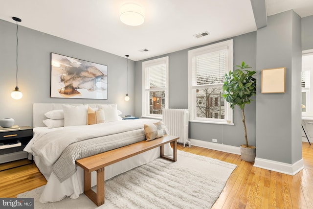 bedroom featuring wood-type flooring and radiator