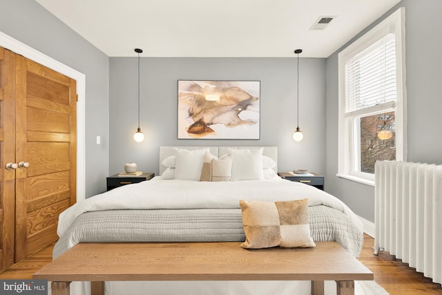 bedroom featuring light hardwood / wood-style flooring and radiator