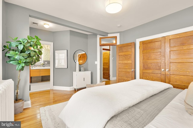 bedroom featuring wood-type flooring and radiator heating unit