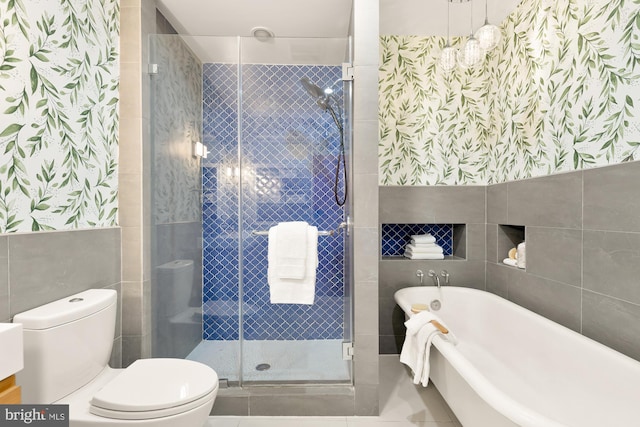 bathroom with independent shower and bath, toilet, tile walls, and tile patterned flooring