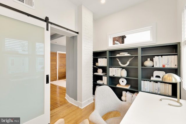 office area with hardwood / wood-style flooring and a barn door