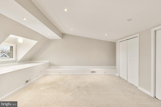 bonus room featuring light carpet and vaulted ceiling