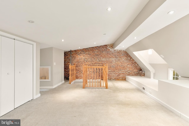 bonus room with light colored carpet, vaulted ceiling, and brick wall