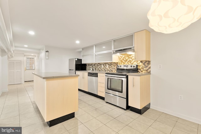 kitchen featuring stainless steel appliances, a kitchen island, light tile patterned floors, and decorative backsplash