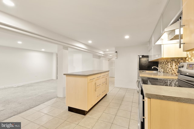 kitchen featuring light brown cabinetry, sink, light colored carpet, decorative backsplash, and stainless steel electric range