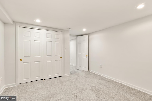 unfurnished bedroom featuring a closet and light colored carpet