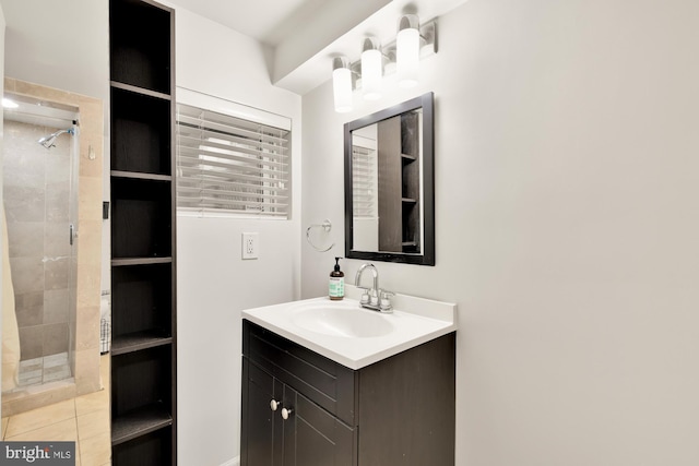 bathroom featuring tile patterned flooring, a shower with shower door, and vanity