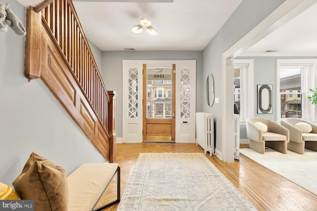 entryway featuring radiator heating unit and light parquet flooring