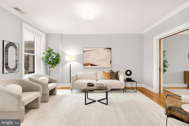 living room featuring a healthy amount of sunlight, light hardwood / wood-style flooring, and crown molding