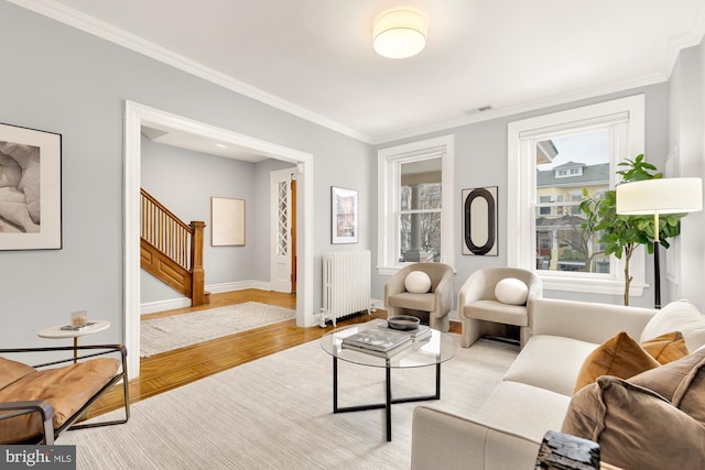 living room with ornamental molding, light hardwood / wood-style flooring, and radiator