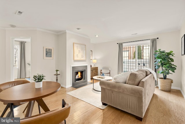 living room featuring light hardwood / wood-style floors and ornamental molding