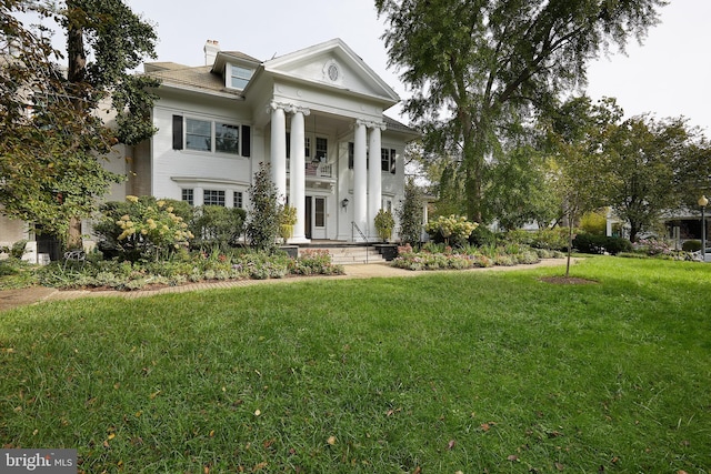 neoclassical / greek revival house featuring a front yard