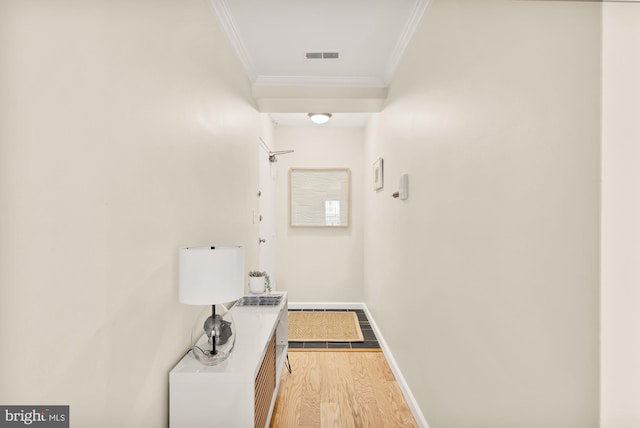 hallway with light wood-type flooring and crown molding