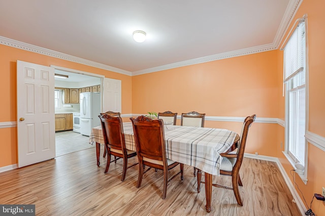 dining room featuring light hardwood / wood-style floors and crown molding