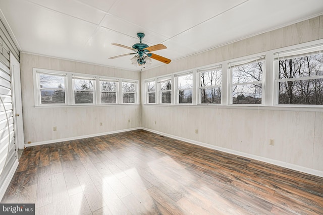 unfurnished sunroom with ceiling fan