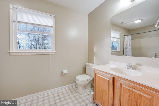 bathroom featuring curtained shower, vanity, and toilet