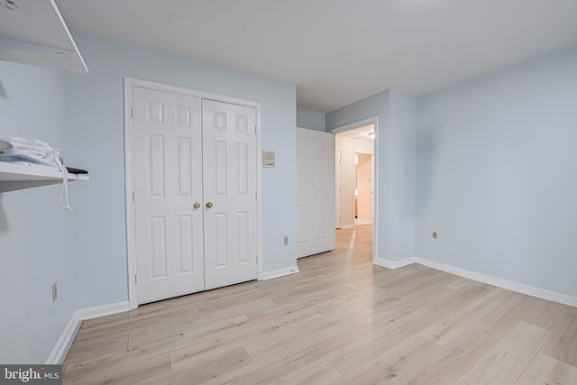 unfurnished bedroom featuring a closet and light wood-type flooring