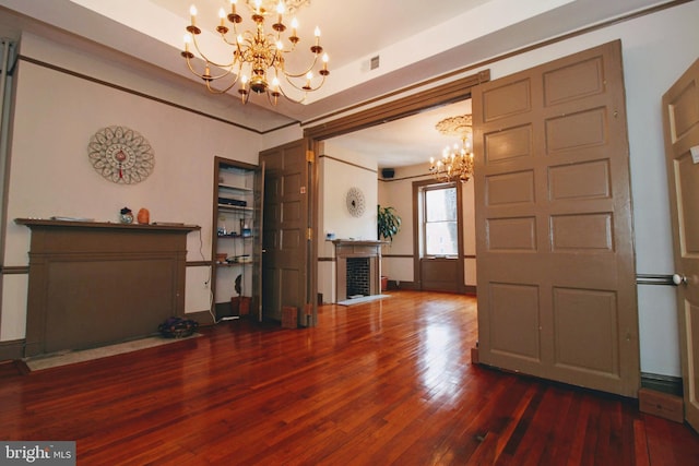 unfurnished living room featuring dark wood-type flooring and a chandelier