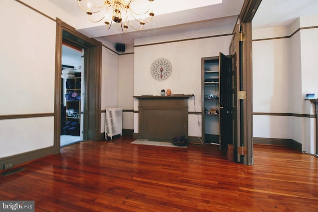 interior space with a notable chandelier, dark hardwood / wood-style floors, and radiator